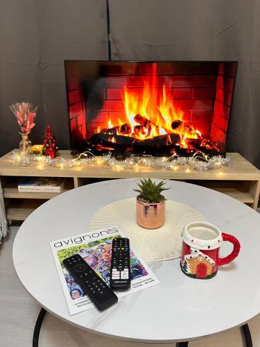 a remote control and a book on a table with a fireplace at Le Quatre in Avignon