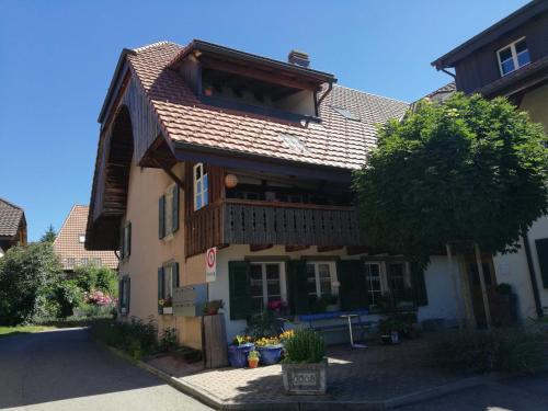 una casa con techo de gambrel en una calle en Maison Seeland-ruhig-Natur-Bern-Murten-Neuenburg, en Kerzers
