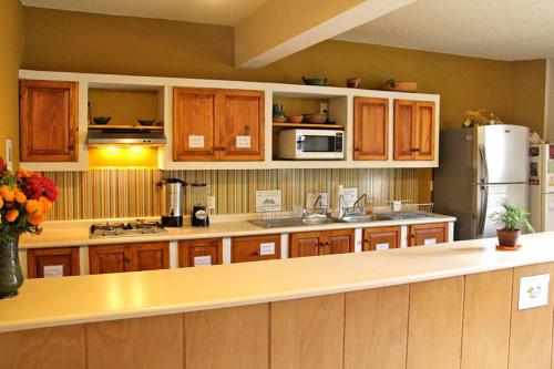 een keuken met houten kasten en een koelkast bij Casa Angel Hostel in Oaxaca City