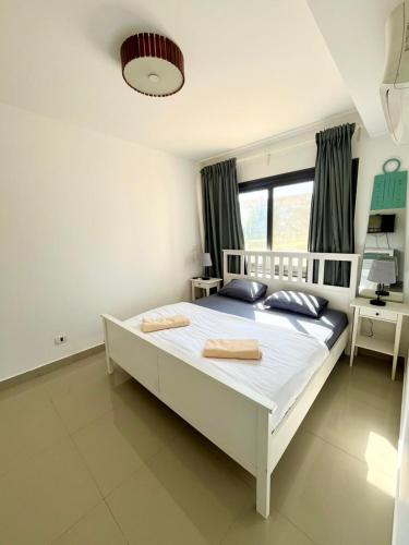 a bedroom with a large white bed with two pillows at El Gouna -G-cribs B6 in El Gouna
