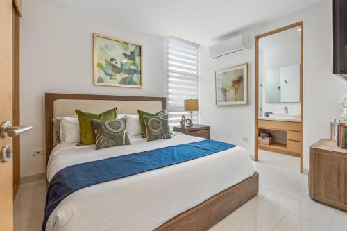 a bedroom with a large bed with green pillows at Modern Condo with Stunning Bay Views in Cabo San Lucas