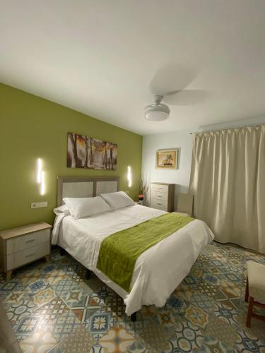 a bedroom with a large bed and green walls at Hostal el Ciervo in Burunchel