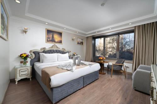 a bedroom with a king sized bed and a desk at Almadina Hotel Istanbul in Istanbul