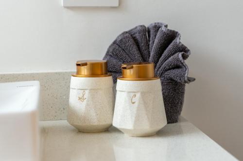 two white vases sitting on a counter in a bathroom at Modern Condo with Stunning Bay Views in Cabo San Lucas