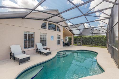 a swimming pool with a glass roof over it at Simba's Lake House in Orlando
