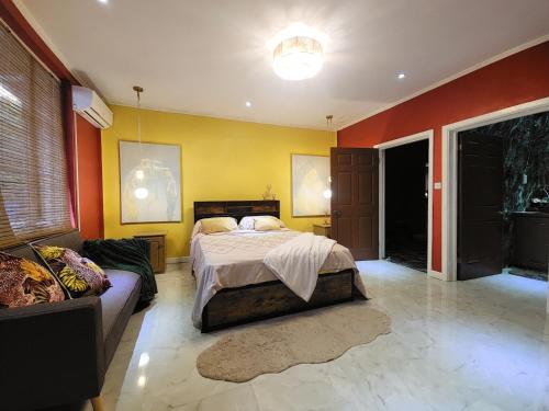a bedroom with a bed and a couch at Hilltop Villa Chez Coco in Rodney Bay Village
