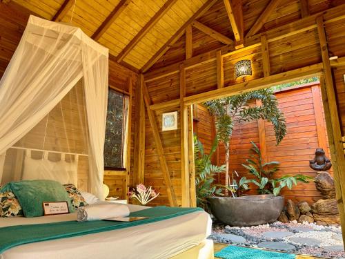 sypialnia z łóżkiem w drewnianym domu w obiekcie Au Jardin Des Colibris Ecolodge&Spa w mieście Deshaies