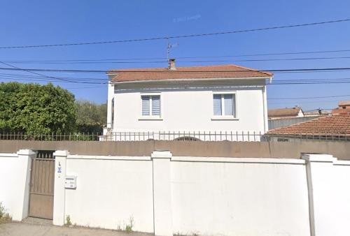 a white house behind a white fence at Le Quatre in Avignon