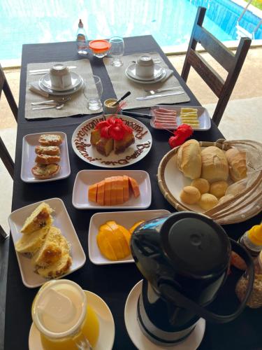 ein schwarzer Tisch mit Teller mit Lebensmitteln drauf in der Unterkunft Eco Pousada Mentawai in Itacaré