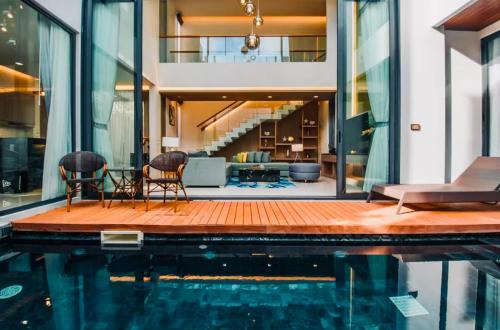 a house with a swimming pool next to a house at Private Villa at Mida Grande Resort in Surin Beach