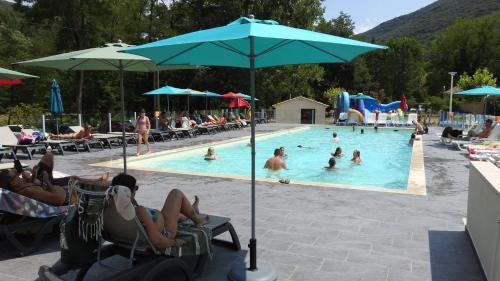a group of people sitting in chairs in a swimming pool at Mobil home cosy 4 personnes - Nature et Détente aux Portes des Cévennes, Mialet in Mialet