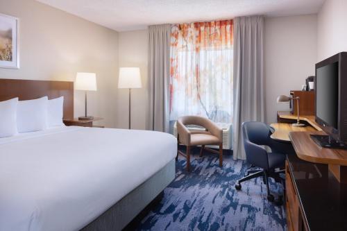 a hotel room with a bed and a desk and a computer at Fairfield Inn & Suites Jacksonville Airport in Jacksonville