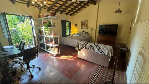 Un dormitorio con cama, escritorio y televisión. en Habitación para 4 en el centro de Asunción con piscina e inmenso jardín, en Asunción