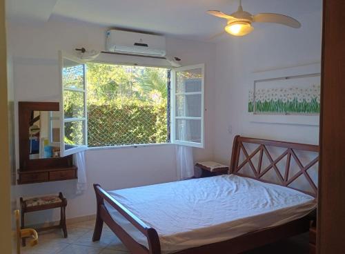 a bedroom with a bed and a window at Camburizinho Casa em condomínio a 250m da praia in São Sebastião
