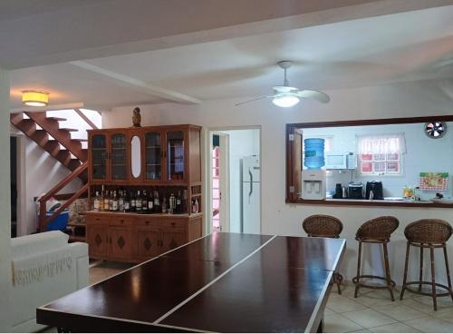 a kitchen with a table and chairs in a room at Camburizinho Casa em condomínio a 250m da praia in São Sebastião