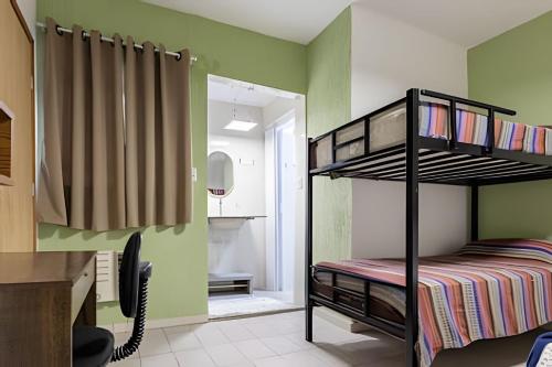 ein Schlafzimmer mit einem Etagenbett und grünen Wänden in der Unterkunft Casinha p/5 Charmosa in Volta Redonda