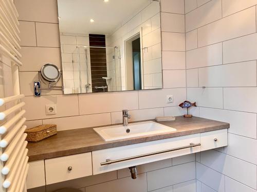een badkamer met een wastafel en een spiegel bij "Windrose" in der Villa am Marienhof in Borkum