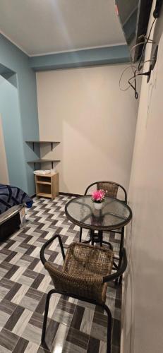 a table with two chairs and a table with flowers on it at Hotel gym club33 in Huancayo