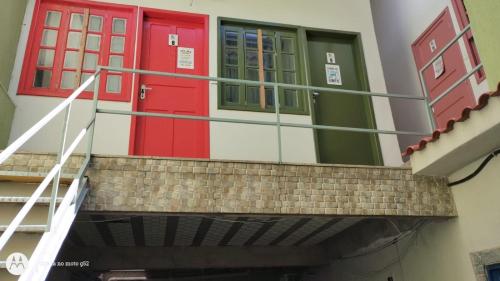 zwei rote und grüne Türen an einem Gebäude in der Unterkunft Chalé Diamante c /AR in Volta Redonda