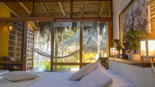 um quarto com uma cama e uma janela grande em Bali Lodge Máncora - Playa, Piscina & Desayuno em Máncora