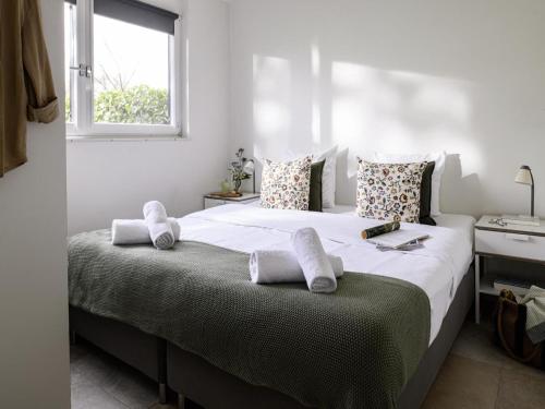 una camera da letto con un letto grande con asciugamani sopra di Relaxing Waterfront Bungalow a Nieuw-Loosdrecht