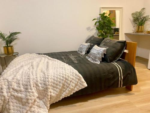 een slaapkamer met een zwart bed en een deken bij APPOVEL- Balkonové Studio in Olomouc