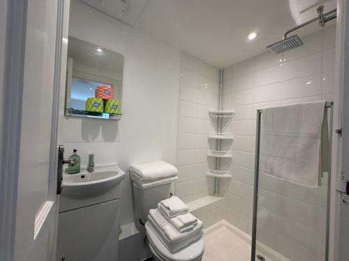 a white bathroom with a toilet and a sink at One bed Mews House in Northwood