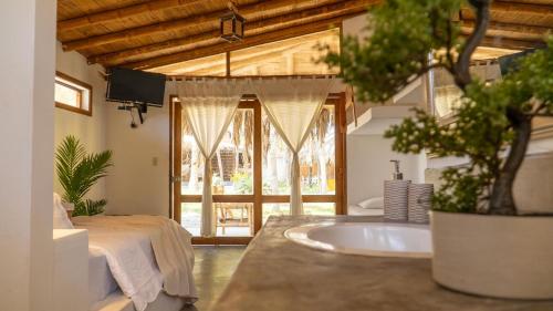 um banheiro com pia, cama e uma árvore em Bali Lodge Máncora - Playa, Piscina & Desayuno em Máncora
