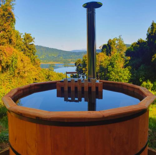 a wooden barrel hot tub with a view of a lake at Casa Pullinque en Panguipulli in Panguipulli