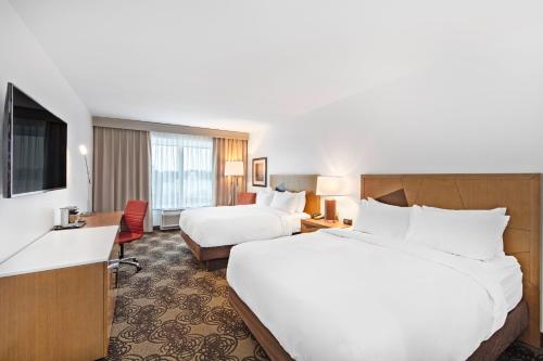 a hotel room with two beds and a television at DoubleTree by Hilton Raleigh-Cary in Cary