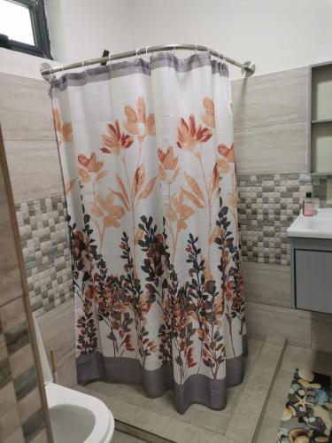 a shower curtain with a flower pattern in a bathroom at Serene Villa in Grand-Baie