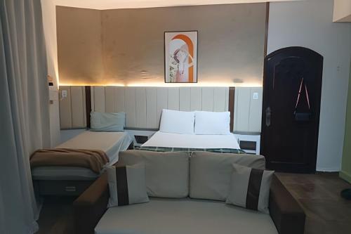 ein kleines Zimmer mit 2 Betten und einem Sofa in der Unterkunft Loft Aconchegante/Climatizado in Miguel Pereira