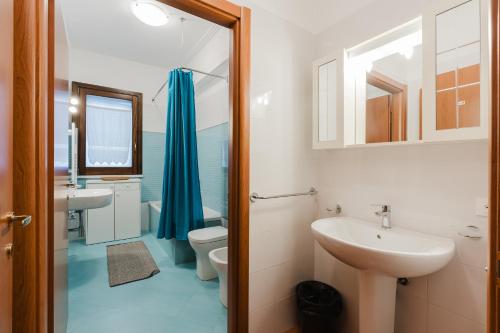 a bathroom with a sink and a toilet and a mirror at Ciciliana in Valderice