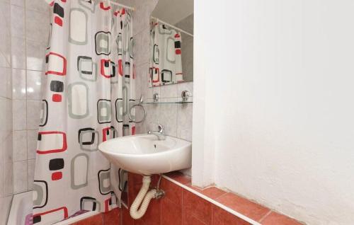 a bathroom with a sink and a shower curtain at Apartment Protrka in Omiš