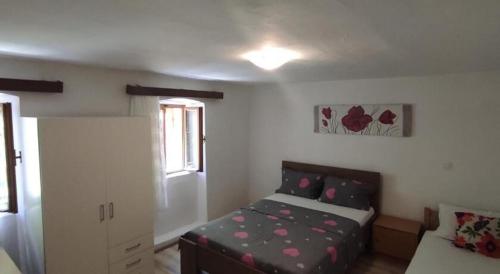 a bedroom with a bed and a couch in it at Apartment Protrka in Omiš