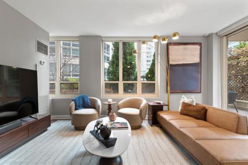 a living room with a couch and a tv at The Bernardin Gold Coast Luxury Apartments Near Magnificent Mile in Chicago