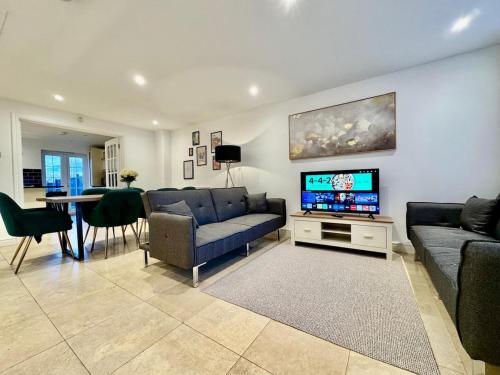 a living room with a couch and a tv at Spacious 5-Bed House in Chigwell - Grange Hill in Chigwell