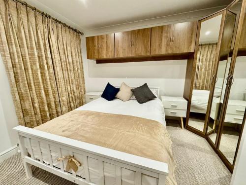 a bedroom with a bed and a large mirror at Spacious 5-Bed House in Chigwell - Grange Hill in Chigwell
