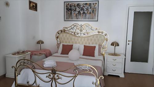 a bedroom with a white bed with a gold frame at La perla di Caserta 2 in Caserta