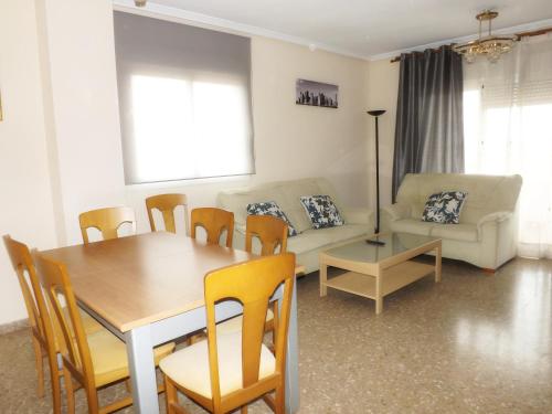 sala de estar con mesa, sillas y sofá en Apartamento Alicante en Alicante