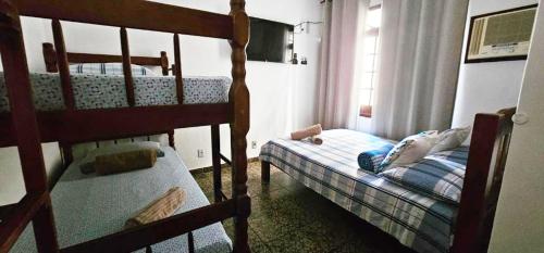 a bedroom with two bunk beds and a window at Suíte Trilha do Sol 2 in Arraial do Cabo