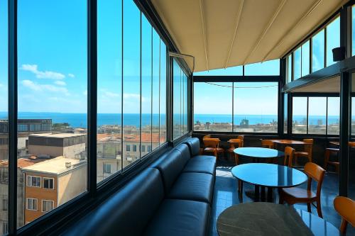 een kamer met een bank, tafels en ramen bij Kaya-Royal-Hotel Beyazit Istanbul All Tea And Coffee Are Complimentary And Available 24-7 On Our Sea View Terrace Restaurant in Istanbul
