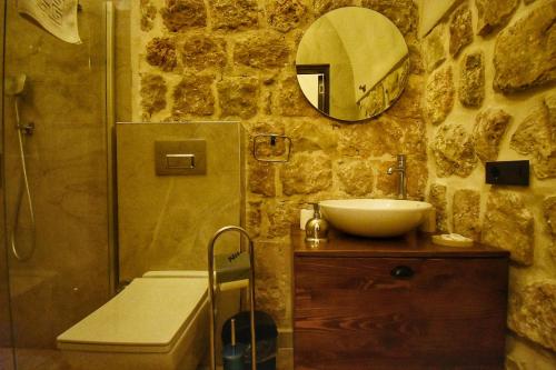 a stone bathroom with a sink and a shower at Mara Loya Konağı in Mardin