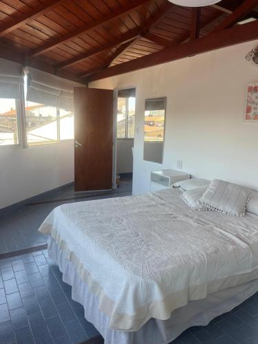 a large white bed in a room with windows at Temporario ARCO IRIS in Concordia