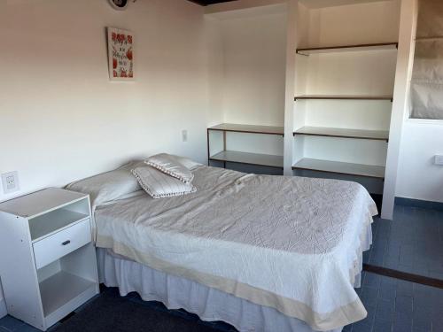 a small bedroom with a bed and shelves at Temporario ARCO IRIS in Concordia