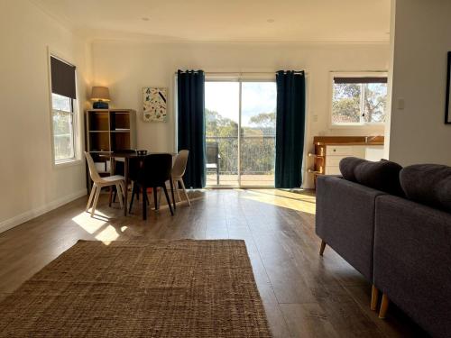a living room with a couch and a table at Happy Mountain House in Blackheath
