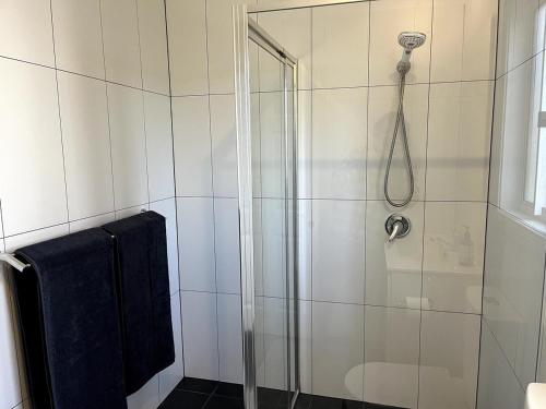 a bathroom with a shower with a glass door at Happy Mountain House in Blackheath