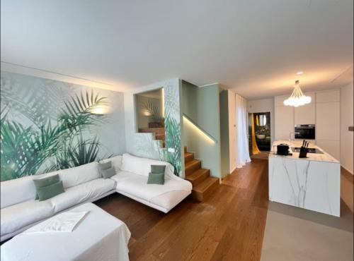 a living room with a white couch and a kitchen at Villa JD in Forte dei Marmi