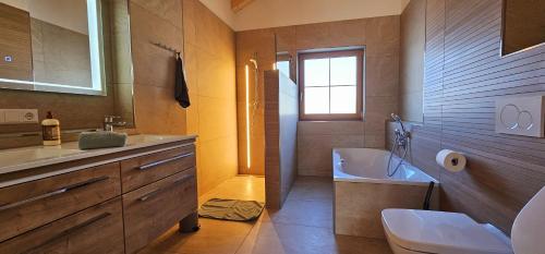 ein Badezimmer mit Badewanne, Waschbecken und Toilette in der Unterkunft Ferienwohnungen Hipp - Bergblick und Wellness in Top Lage in Halblech