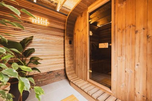 a wooden sauna with a window and a plant at Health & Wellness House Hot Tub, Sauna & Ice Bath in Netley